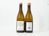 deux bouteilles de vin posées l'une à côté de l'autre sur une surface blanche
