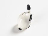a white and black cat figurine sitting on a white surface