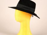 un chapeau noir posé sur la tête d'un mannequin, sur fond blanc