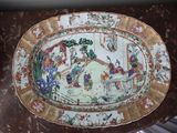 a plate with a painting on it sitting on a table