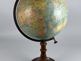 an old globe on a wooden stand with a white background