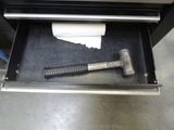 a hammer and a roll of toilet paper in an open drawer