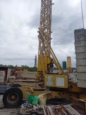 une grue posée au sommet d'un tas de bois