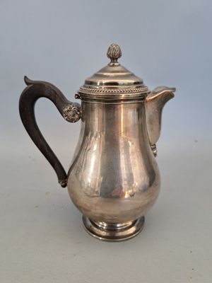 cafetière plaquée argent avec une anse, posée sur un fond blanc