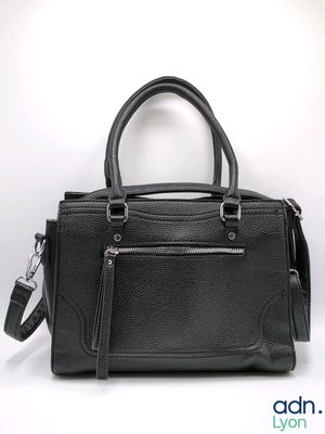the black leather handbag is sitting on a white surface