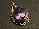 an image of a purple stone pendant sitting on top of a table