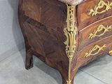 a wooden chest of drawers with a marble top