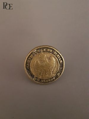 gros plan d'une pièce d'or sur une surface blanche