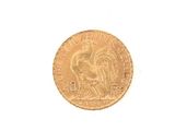 a gold coin with a rooster on it on a white surface