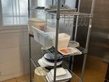a kitchen with a stainless steel shelving and lots of dishes on it