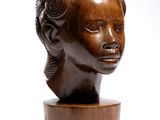 wooden sculpture of a woman ' s head on a wooden stand