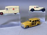 deux petites voitures miniatures exposées sur une étagère transparente