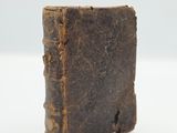an old book sitting on top of a white surface