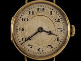 un gros plan d'une montre-bracelet en or sur fond noir
