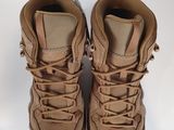 the back of a pair of tan hiking boots on a white surface