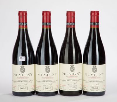 trois bouteilles de vin rouge sont alignées sur une surface blanche