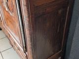 a tall wooden cabinet in the corner of a room
