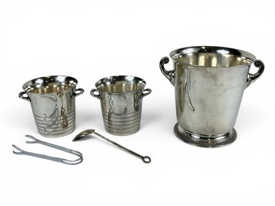 trois tasses en argent et une cuillère posées les unes à côté des autres