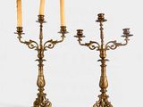 paire de chandeliers anciens en laiton avec des bougies posées sur des socles