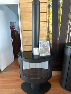un poêle noir posé à côté d'une table noire sur laquelle se trouve une photo