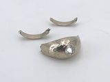 paire de boucles d'oreilles en argent posées sur une surface blanche, sur fond blanc