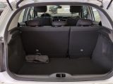 the back of a white car with the trunk open and luggage in the trunk