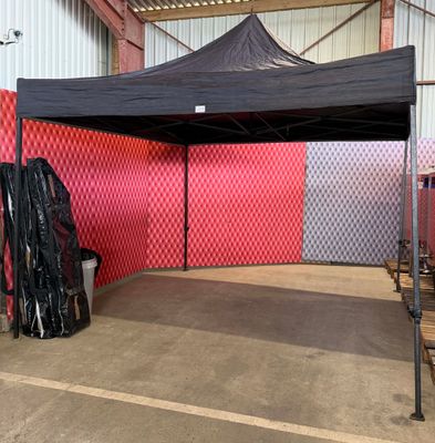 une tente située dans un bâtiment, avec un mur rouge en arrière-plan
