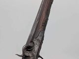 an old gun that is sitting on top of a wooden stand