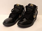 black and gold nike air jordans on a white surface