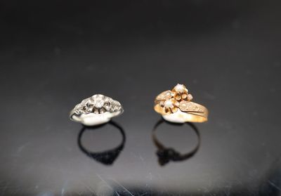deux bagues en or et en argent ornées de têtes de mort, posées sur une surface noire