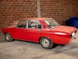 a red car parked in a garage next to a brick wall