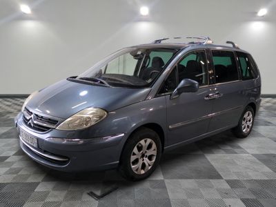 une photo d'un monospace gris garé dans un garage