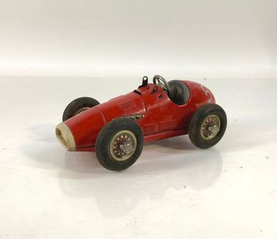 une petite voiture rouge posée sur une surface blanche