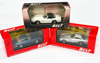 trois boîtes contenant des petites voitures, posées sur une surface blanche