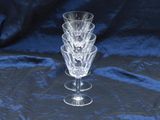 four wine glasses stacked on top of each other on a blue cloth