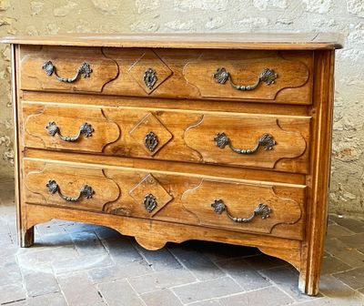 a wooden chest of drawers sitting on a tiled floor