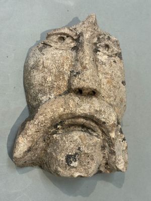 a stone sculpture of a face on the wall