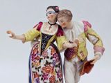 a figurine of a man and a woman holding a purse