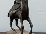 a statue of a man riding a horse on a wooden base