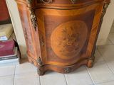 a vase on top of a wooden cabinet with a marble top