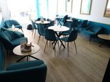 tables and chairs in a room with blue walls and wood flooring