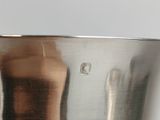 a silver vase with a hand sticking out of it