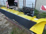 a large yellow plow sitting in front of a building