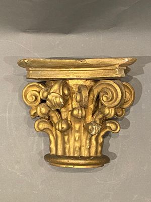 une sculpture en or accrochée au mur, à côté d'une horloge