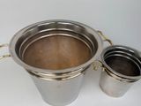 a metal bucket and a metal cup on a white surface