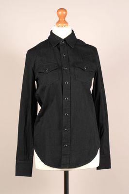 une chemise noire sur un présentoir à mannequin