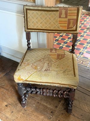 a wooden chair with a seat that has a design on it