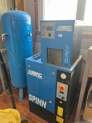 une machine bleue et un seau jaune posés sur un parquet en bois massif