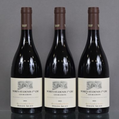 three bottles of wine are lined up on a table
