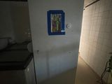 a white refrigerator in a dark room with a blue door